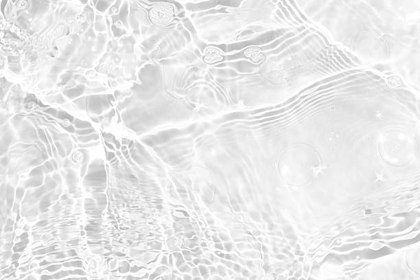 istock White water with ripples on the surface. Defocus blurred transparent white colored clear calm water surface texture with splashes and bubbles. Water waves with shining pattern texture background. 2235447767