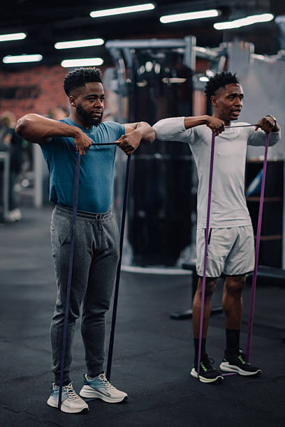 istock Two young men doing resistance band exercises in the gym 2235448782