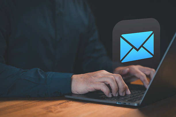 istock Hands typing on a laptop keyboard with a glowing email icon above, symbolizing digital communication, online messaging, or professional email services. 2235450042
