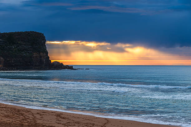 istock Winter sunrise by the sea shore with rain clouds 2235450057