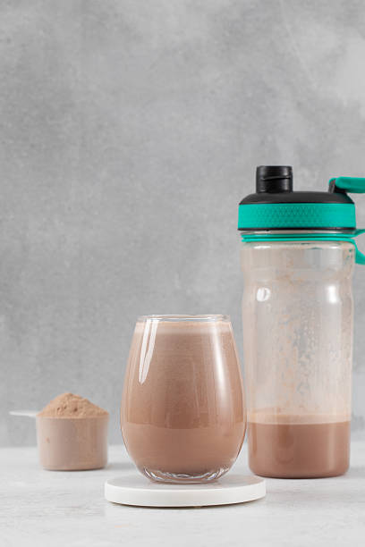 istock Chocolate protein shake with powder and shaker bottle on a light gray background 2235453418
