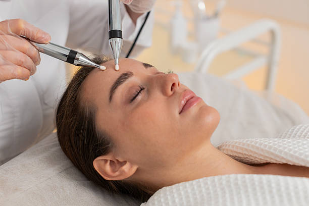 istock Beautician doctor makes woman micro currents face therapy using electrical impulses in spa salon 2235454738