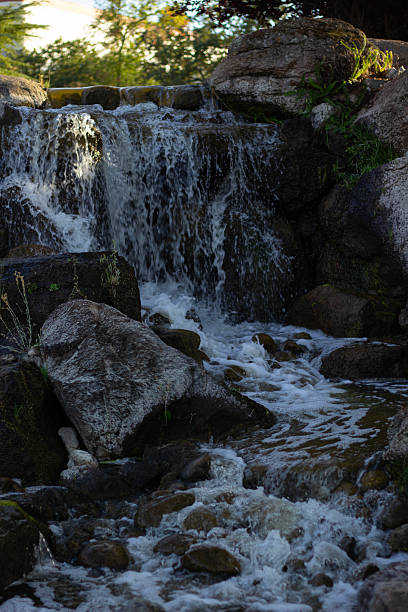 istock Water Cascades Over Rocks Creating a Serene Waterfall in a Natural Landscape During a Sunny Afternoon 2235464643