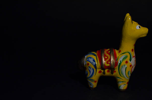 Decorative yellow souvenir llama isolated on black background.