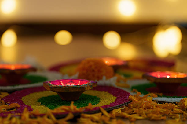 istock Diwali Festivity. Glowing Diyas on Colorful Rangoli Design. 2235470623