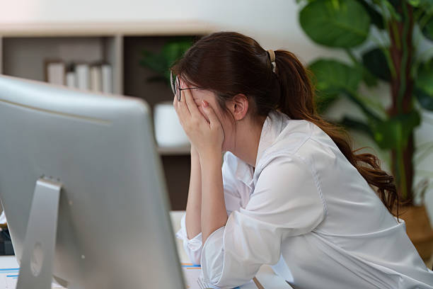 istock Workplace Stress. Young woman showing signs of distress while working. 2235470657