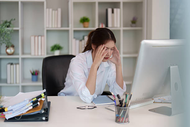 istock Stress Management. Young woman with headache while working on computer. 2235470682
