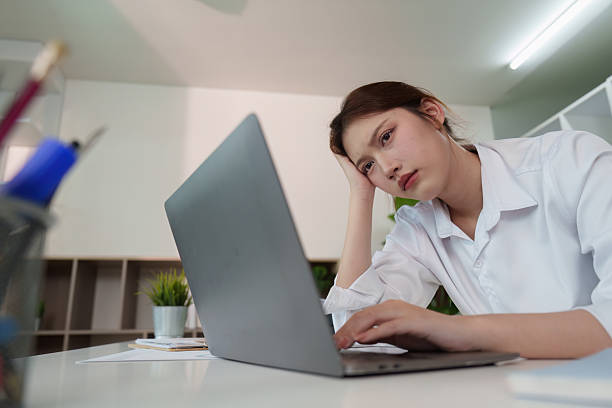 istock Stressed young woman working on laptop in modern office 2235471634