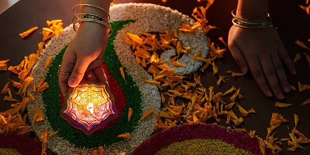 istock Diwali Tradition. Hand Placing Diyas on Colorful Rangoli. 2235471770