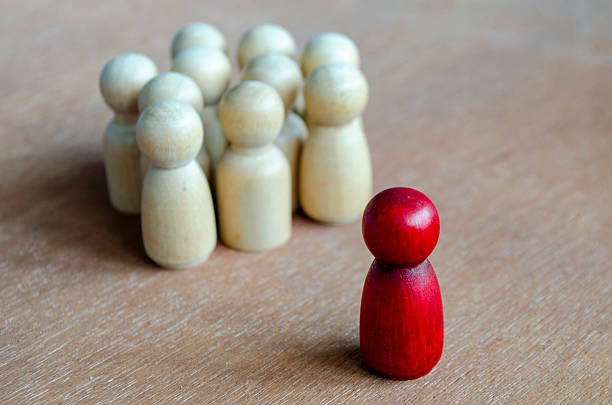 istock A red figurine confronting a cluster of beige figurines symbolizing opposition that can reflect leadership or harassment. 2235473156