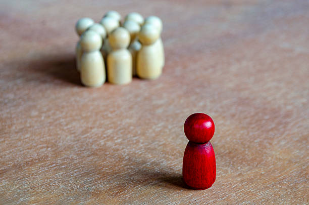 istock A red figurine apart from beige figurines symbolizing isolation that can indicate leadership or harassment. 2235473175