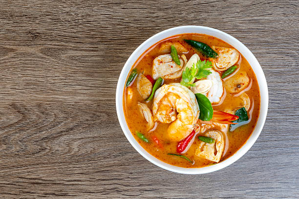 istock Prawn Tom Yum in a white bowl on a wooden table 2235476574