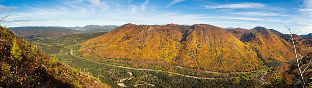 istock Vibrant autumn landscape showcasing rolling hills, dense forests, and a winding river in a mountainous region during daylight hours 2235478172