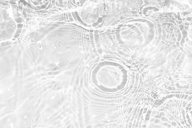 istock White water with ripples on the surface. Defocus blurred transparent white colored clear calm water surface texture with splashes and bubbles. Water waves with shining pattern texture background. 2235482595