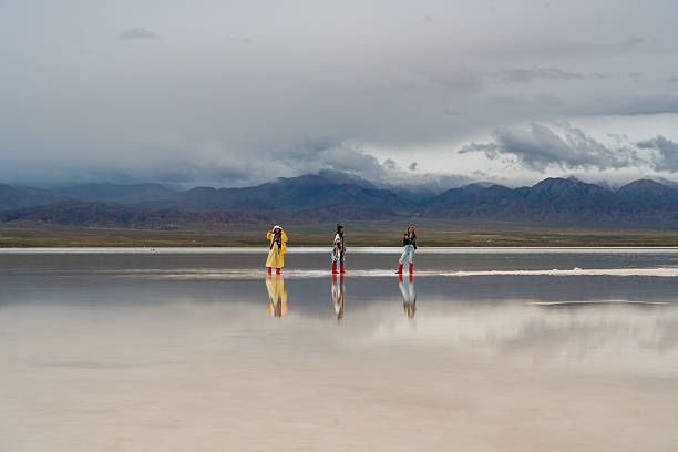 istock Three people are moving forward across big landscape, reflecting hope for future in shimmering water. mountains in background add to serene beauty of scene 2235485044