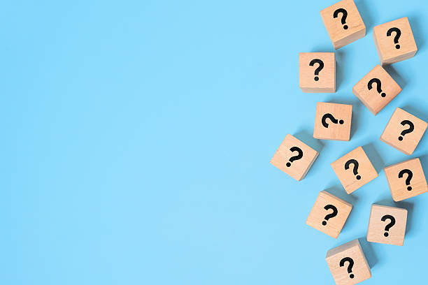 istock Many question mark signs on wood blocks on blue paper background with copy space 2235485473