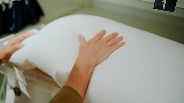 istock Man checking pillow on shelf while shopping for house decor in a mall. 2235492498