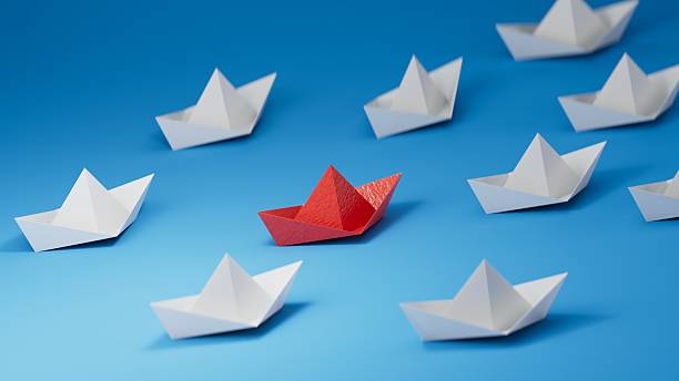 istock Different business concept.new ideas. paper art style. creative idea. red leader boat, standing out from the crowd of white boats.3D rendering on blue background. 2235494763