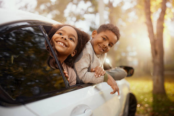 istock Happy black kids enjoying through car window in nature. 2235498716