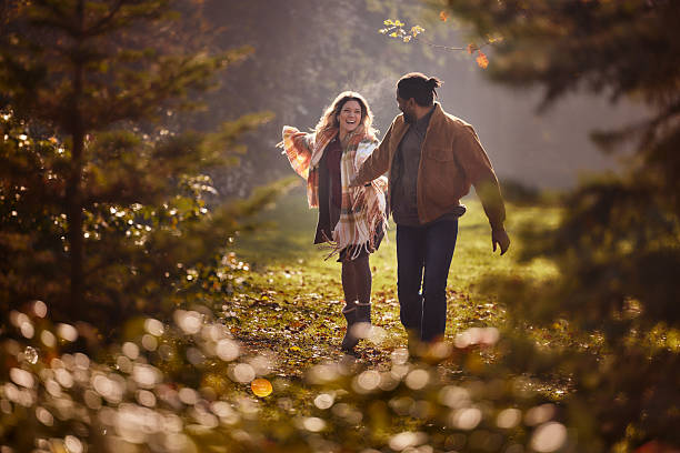 istock Playful diverse couple running during autumn in nature. 2235498745