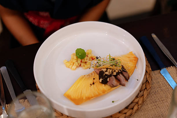 Pineapple on a plate with a fork on a white background