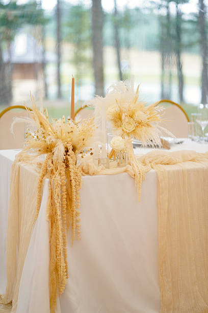 istock Wedding table with white tablecloth decorated with dried flowers, blooms and candles. 2235499336