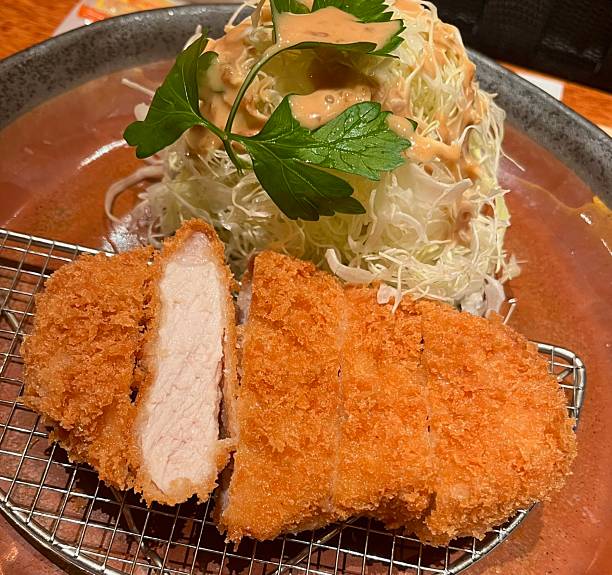 istock Crispy tonkatsu, a Japanese-style breaded and deep-fried pork cutlet, served with shredded cabbage and drizzled with savory sauce. A delightful balance of crunchy texture and juicy meat. 2235500775
