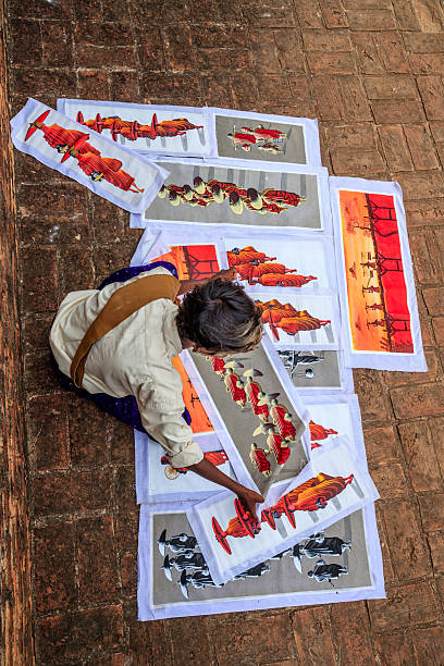 Young Burmese boy with thanaka face paint selling souvenirs - sand paintings, in the ancient temple of Bagan, Myanmar (Burma)