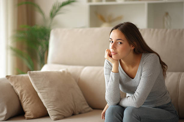 istock Relaxed woman at home looking at camera on a couch 2235501341