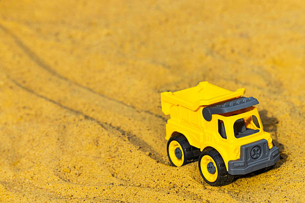istock toy yellow car in sandbox, close up 2235502967