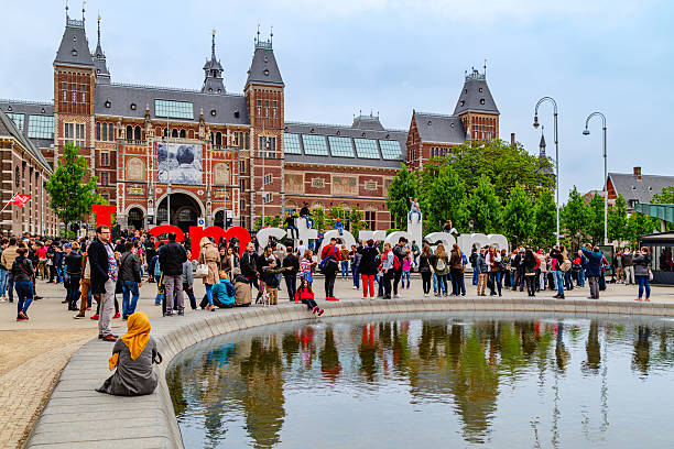 Amsterdam, Netherlands-April, 11. 2022: Rijksmuseum on Museumplein with crowds of tourists.