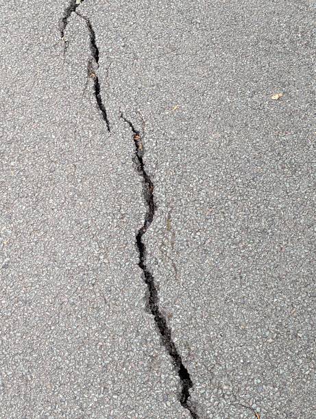 istock A crack forming in asphalt due to subsidence 2235505476