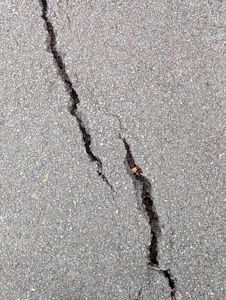 istock A crack forming in asphalt due to subsidence 2235505478