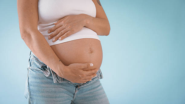 Pregnant Woman in Studio Touching Belly