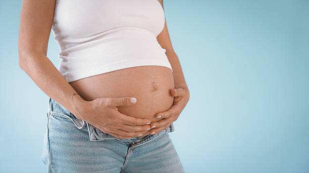 istock Pregnant Woman in Studio Touching Belly 2235505519