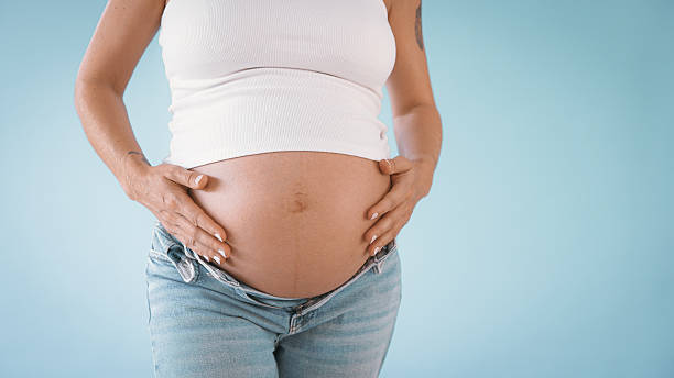 istock Pregnant Woman in Studio Touching Belly 2235505535