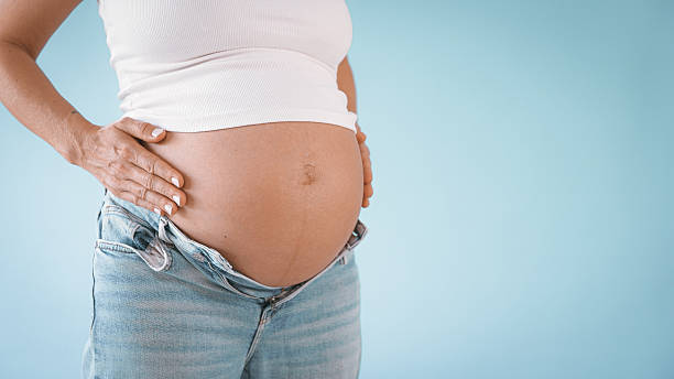 istock Pregnant Woman in Studio Touching Belly 2235505542