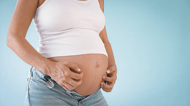 istock Pregnant Woman Scratching Belly in Studio 2235505572