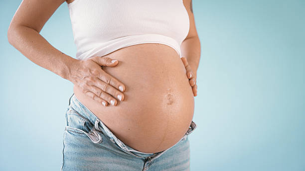istock Pregnant Woman Applying Lotion on Belly 2235505593