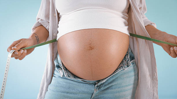 istock Pregnant Woman Measuring Belly 2235505687