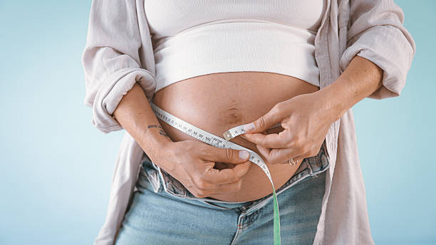 istock Pregnant Woman Measuring Belly 2235505689