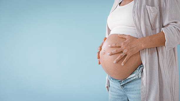 istock Pregnant Woman in Studio Touching Belly 2235505740