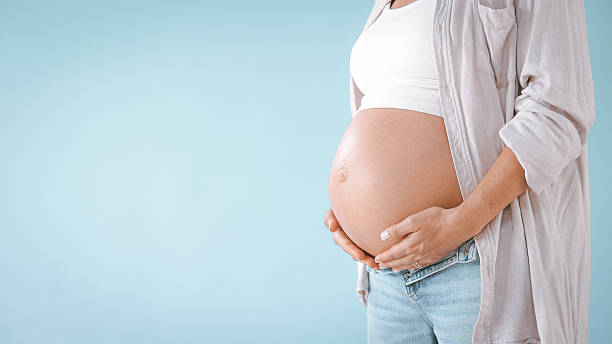 istock Pregnant Woman in Studio Touching Belly 2235505752