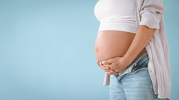 istock Pregnant Woman in Studio Touching Belly 2235505782