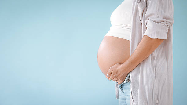 Pregnant Woman in Studio Touching Belly