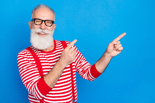 istock Portrait of attractive elderly cheerful man demonstrating copy space ad solution isolated over bright blue color background 2235507934