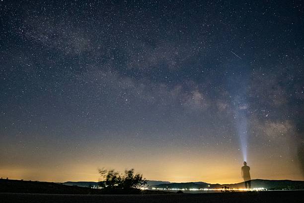 istock Silhouette under a starry night sky with Milky Way. 2235508275