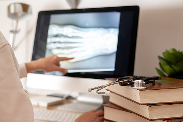 istock Medical student is pointing at an x-ray image displayed on a computer screen, with medical books and a stethoscope nearby, symbolizing online medical education and healthcare learning 2235508877
