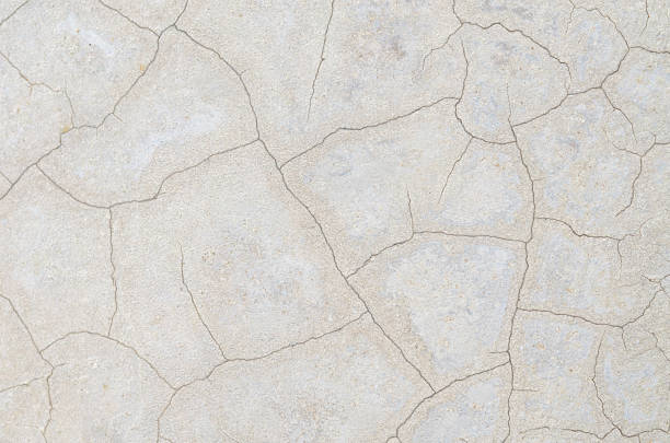 A top-down view of a light gray, fractured surface, perfect as a versatile background for concepts of aging, decay, or urban grunge.
