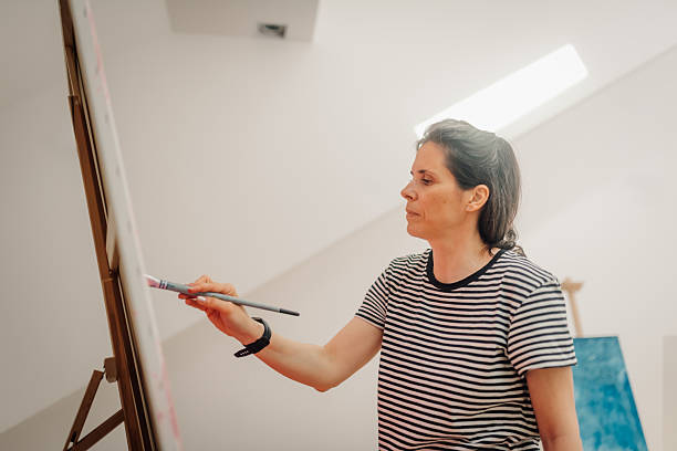 istock Female artist painting on canvas in art studio: creative expression and artistic process 2235509389